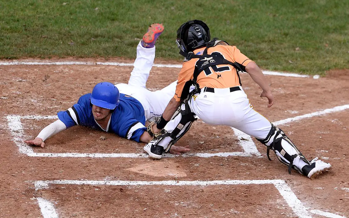 Play at the plate. Runner sliding into home catcher tagging out